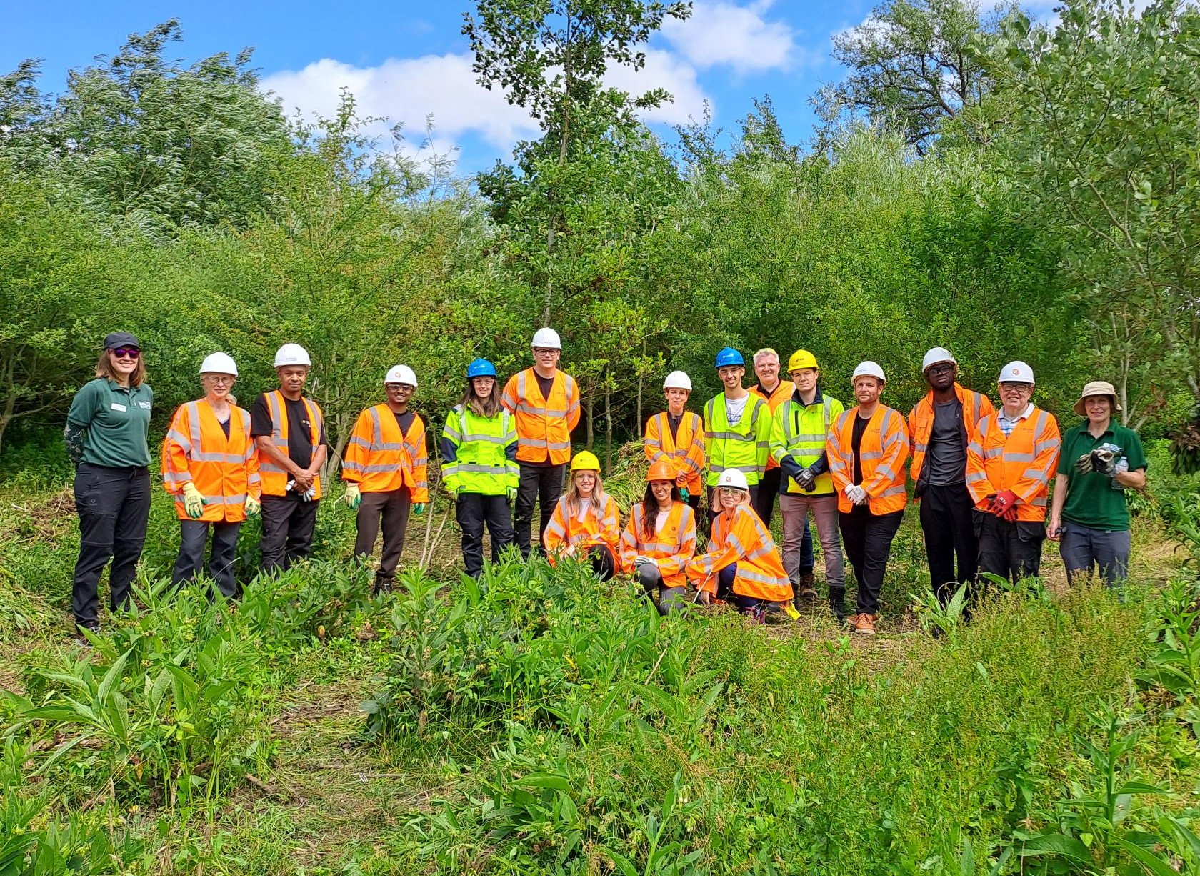 Team of men and women outdoors wearing high vis and hard hats