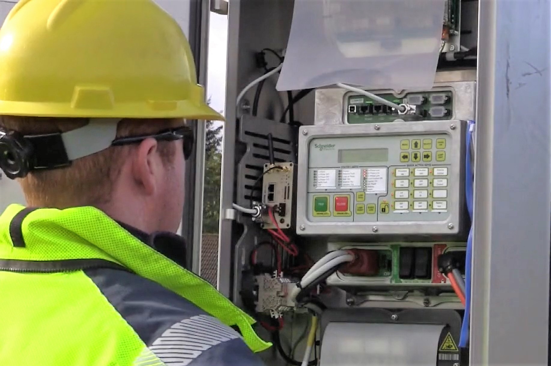Engineer in high vis and hard hat at circuit board