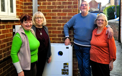 The four trustees of Dilton Memorial Hall stand in front of the heat pump installed with SSEN community funding