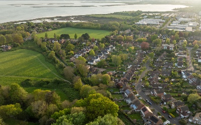 An aerial view of part of SSEN Distribution's central southern England licence area, showing houses, fields, industrial units and open water