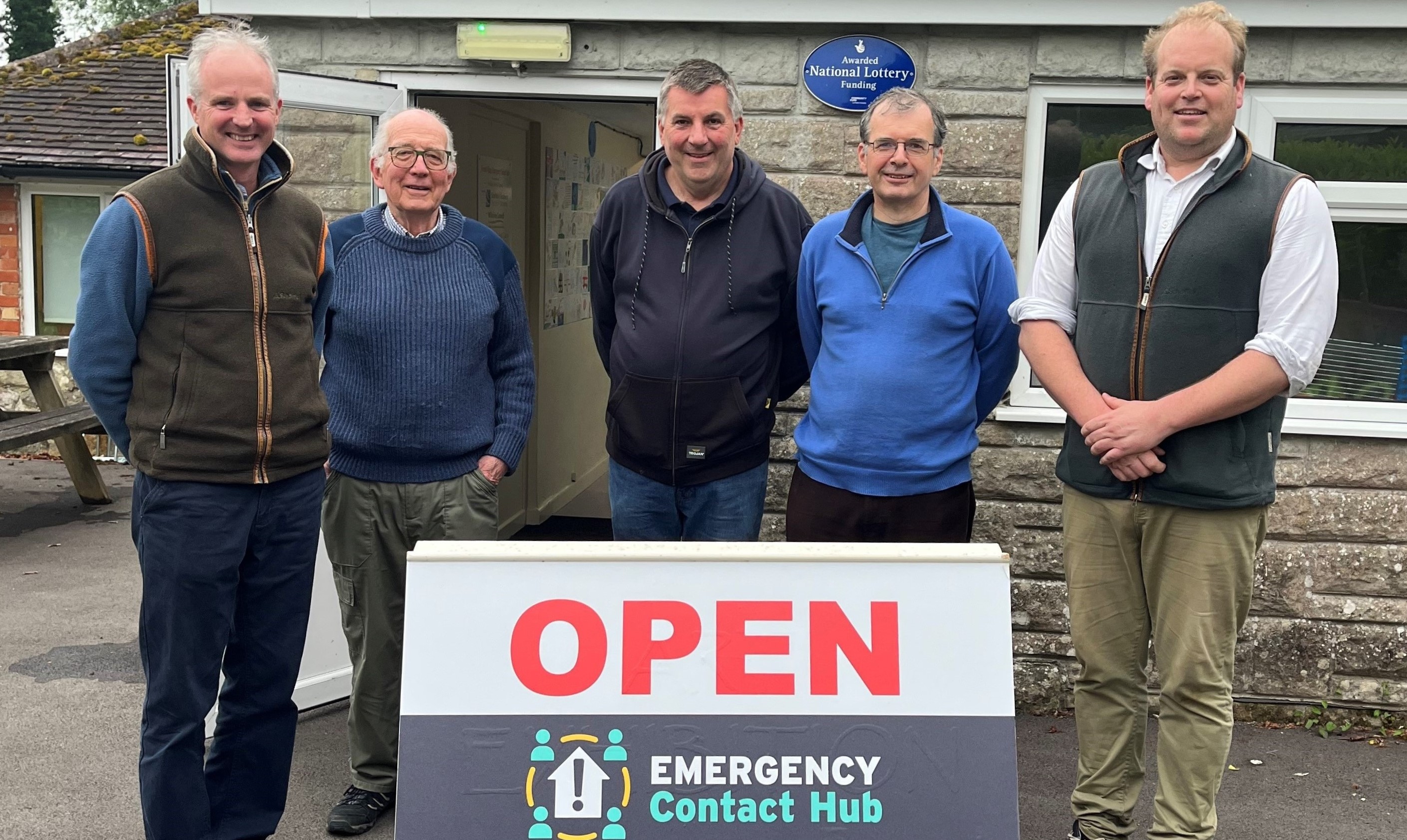 Group of men outside village hall