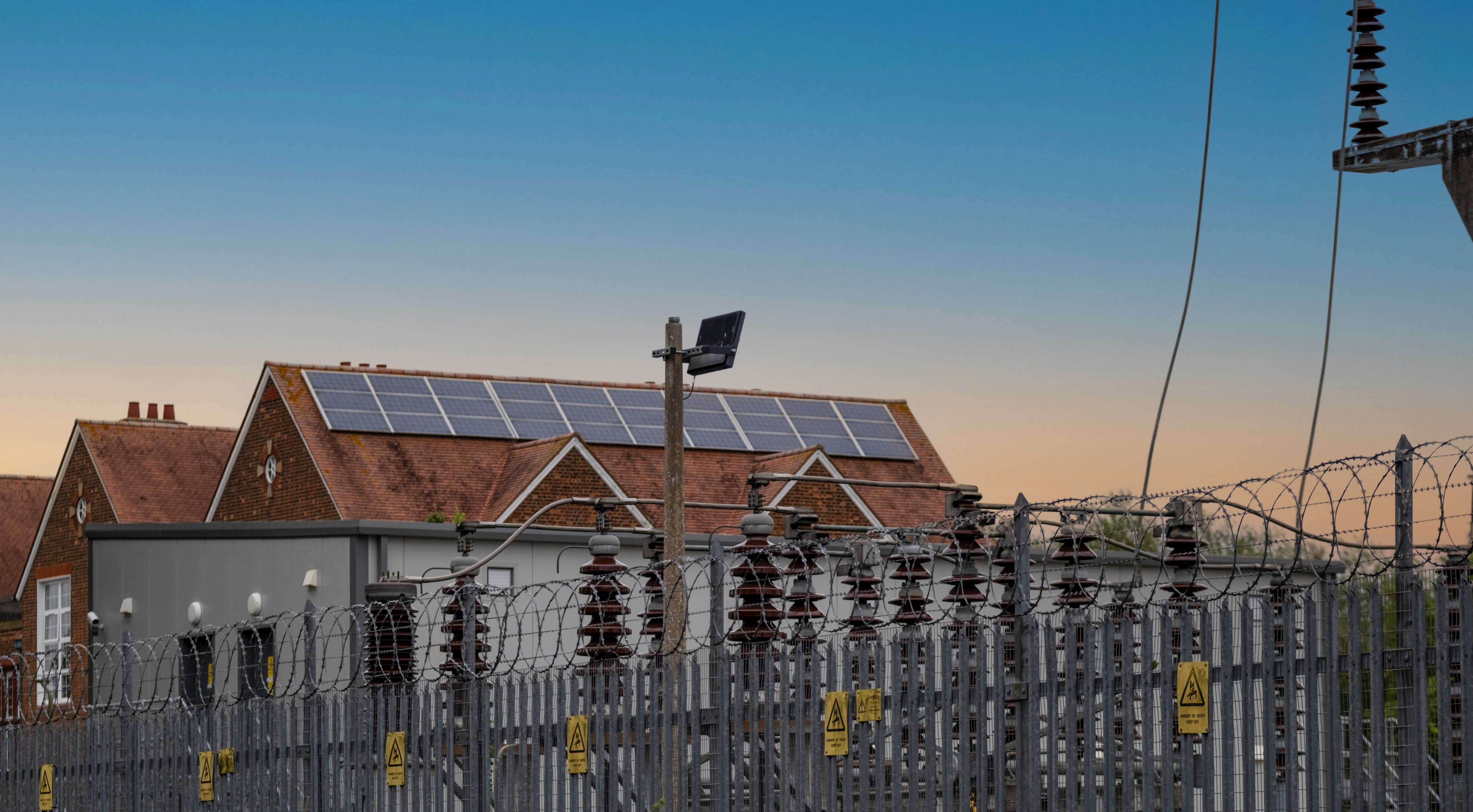 House with solar panels next to electricity infrastructure