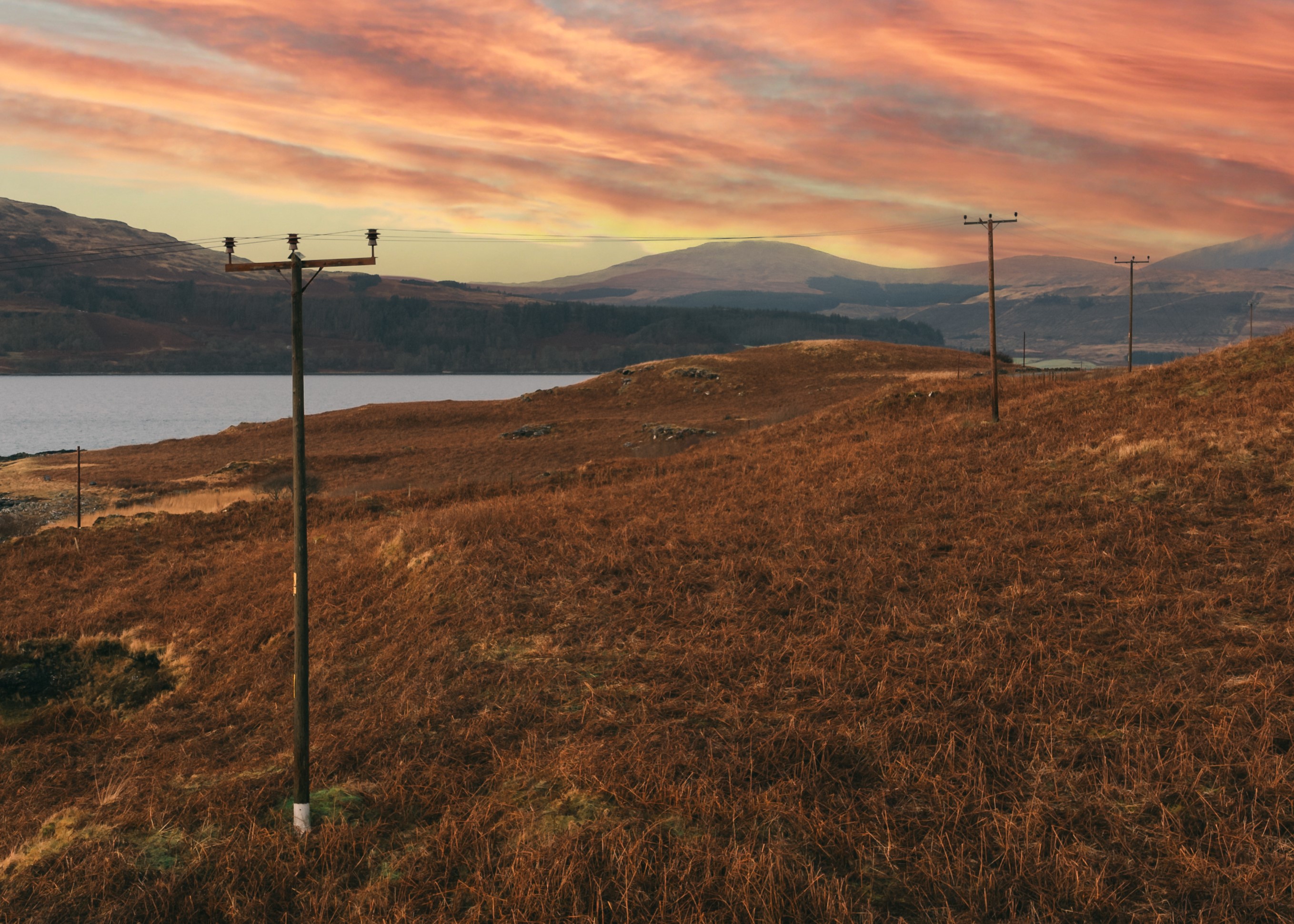 An SSEN Distribution overhead power line running through rural Scottish landscape