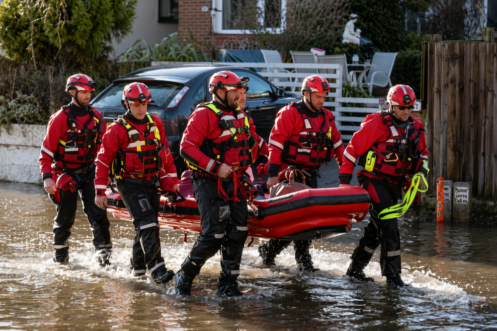 Rescue workers in red kit carrying life boat