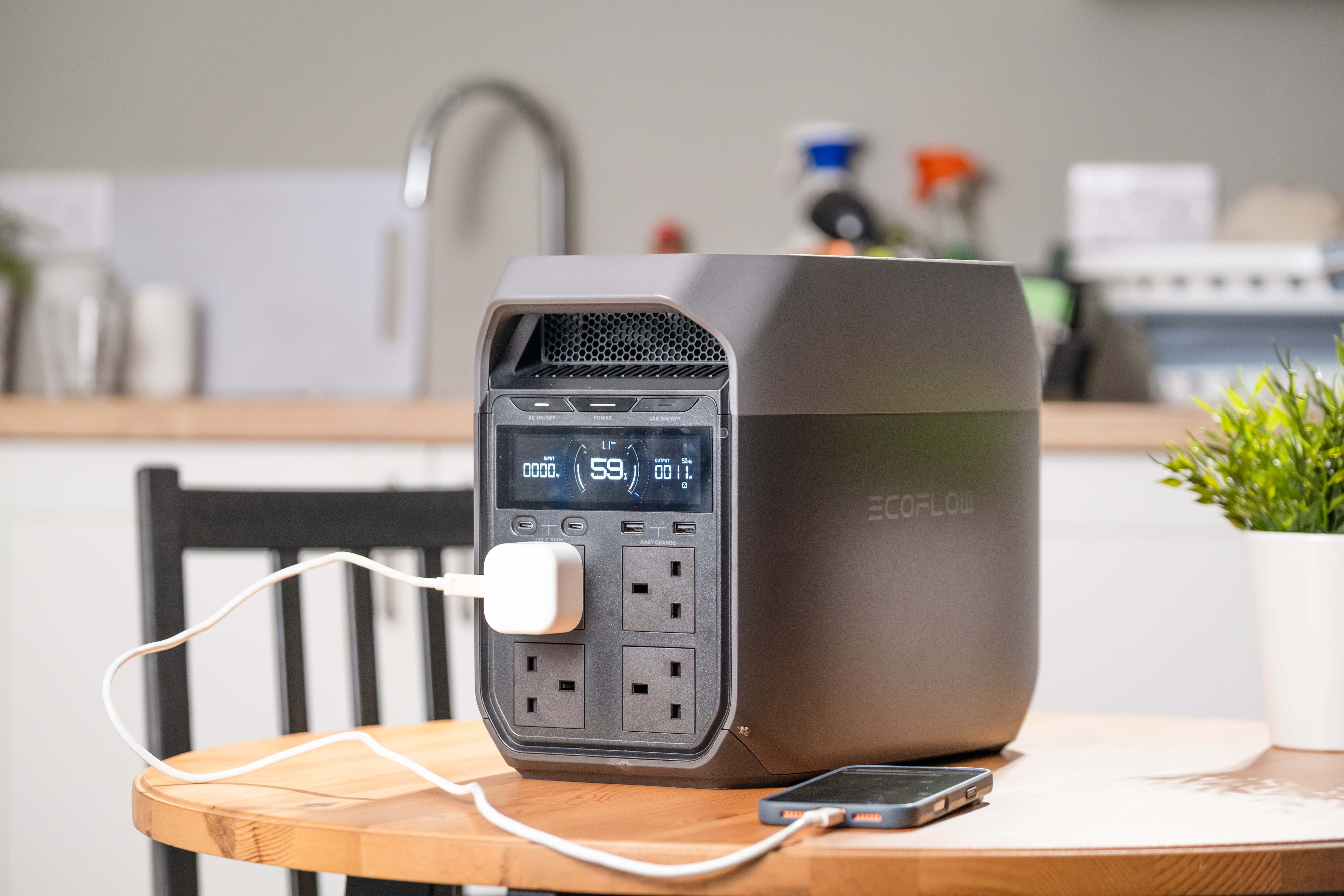 Battery pack on table, charging with plug.